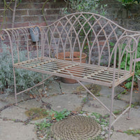 Painted wrought iron garden bench with Gothic arch back, scroll armrests and slatted seat