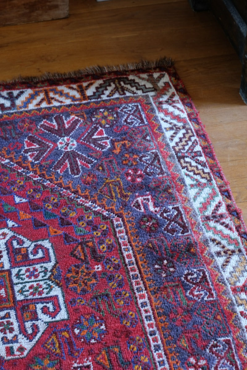 Persian Shiraz rug with a red ground depicting animals and floral motifs