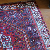 Persian Shiraz rug with a red ground depicting animals and floral motifs