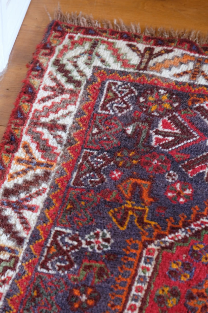 Persian Shiraz rug with a red ground depicting animals and floral motifs