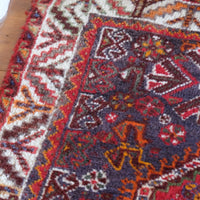 Persian Shiraz rug with a red ground depicting animals and floral motifs