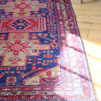 A vintage Kordi handmade wool rug runner with a geometric pattern primarily in blue and red colors.