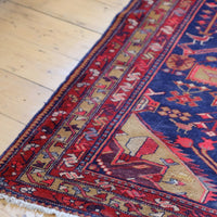 A vintage Kordi handmade wool rug runner with a geometric pattern primarily in blue and red colors.