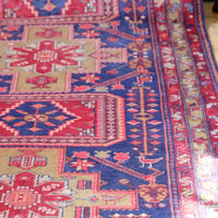 A vintage Kordi handmade wool rug runner with a geometric pattern primarily in blue and red colors.