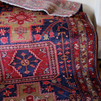 A vintage Kordi handmade wool rug runner with a geometric pattern primarily in blue and red colors.