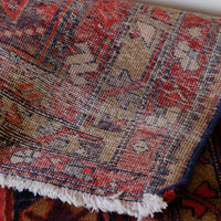 A vintage Kordi handmade wool rug runner with a geometric pattern primarily in blue and red colors.