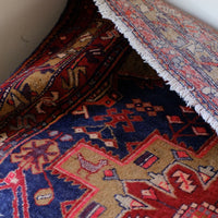 A vintage Kordi handmade wool rug runner with a geometric pattern primarily in blue and red colors.