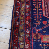 A vintage Kordi handmade wool rug runner with a geometric pattern primarily in blue and red colors.