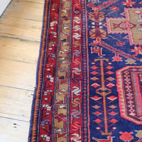 A vintage Kordi handmade wool rug runner with a geometric pattern primarily in blue and red colors.
