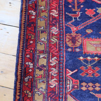 A vintage Kordi handmade wool rug runner with a geometric pattern primarily in blue and red colors.