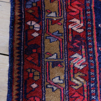 A vintage Kordi handmade wool rug runner with a geometric pattern primarily in blue and red colors.