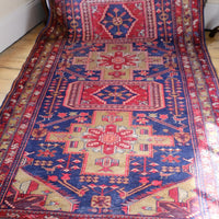 A vintage Kordi handmade wool rug runner with a geometric pattern primarily in blue and red colors.