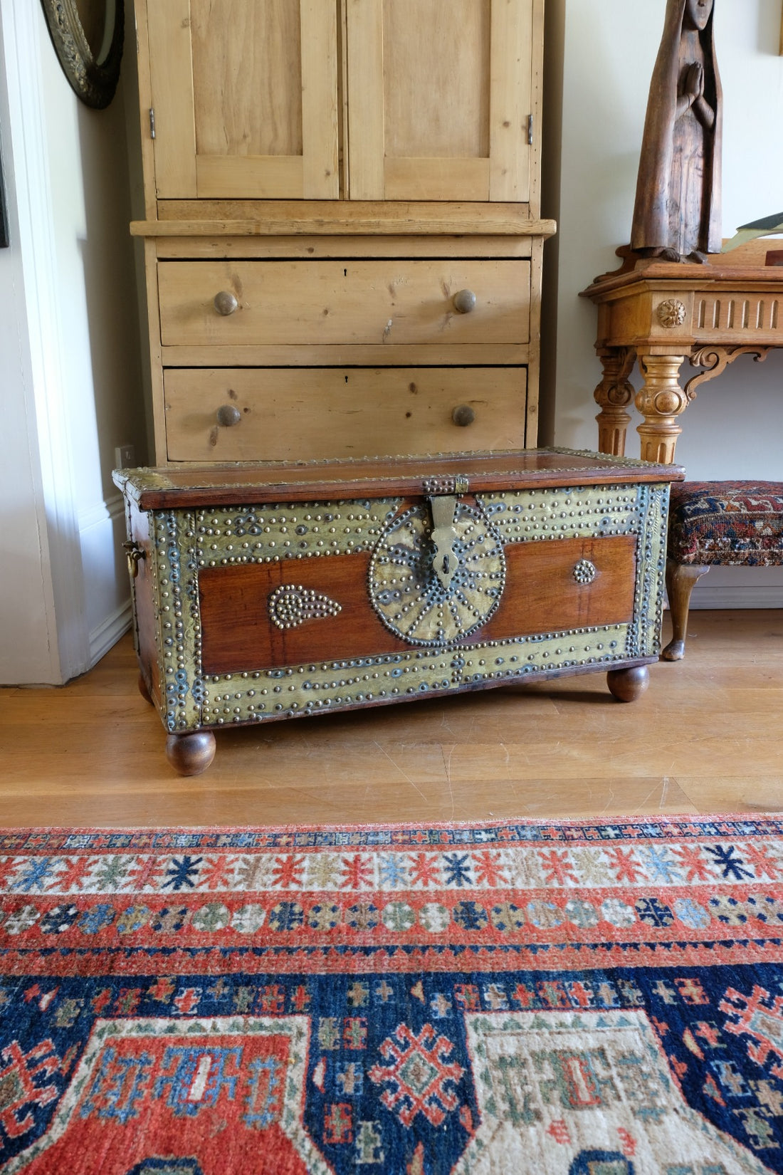 Teak Zanzibar chest decorated with brass studs raised on bun feet
