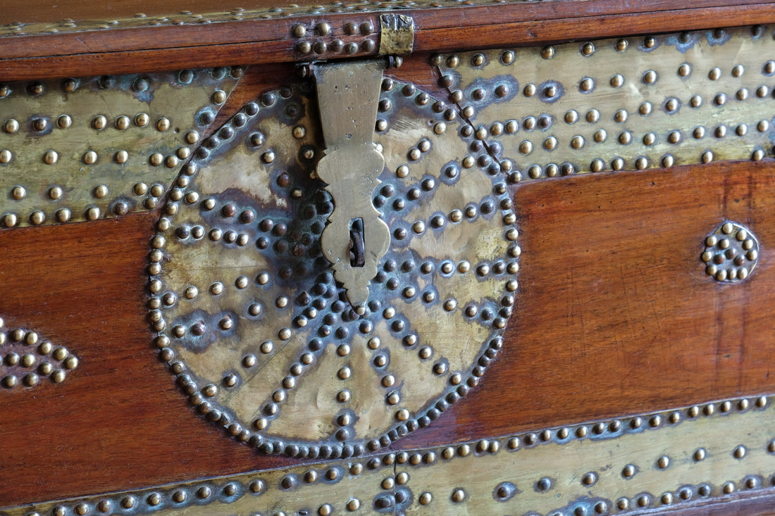 Teak Zanzibar chest decorated with brass studs raised on bun feet