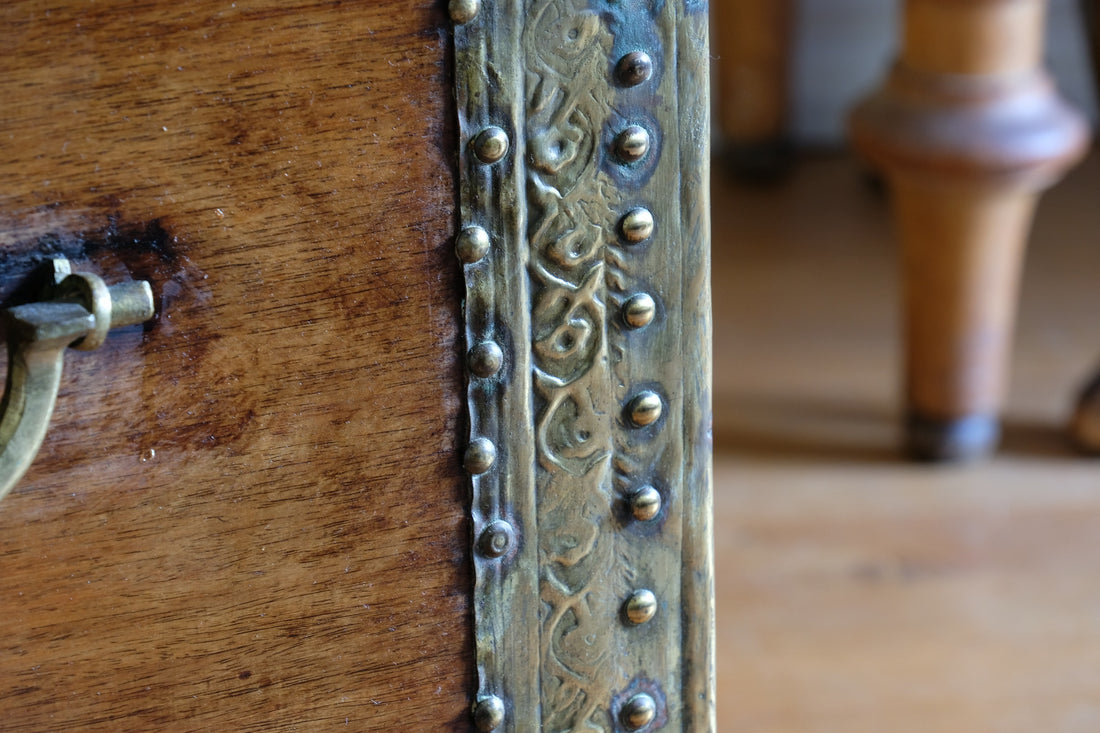 Teak Zanzibar chest decorated with brass studs raised on bun feet