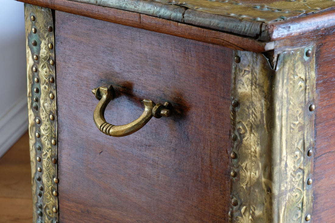Teak Zanzibar chest decorated with brass studs raised on bun feet