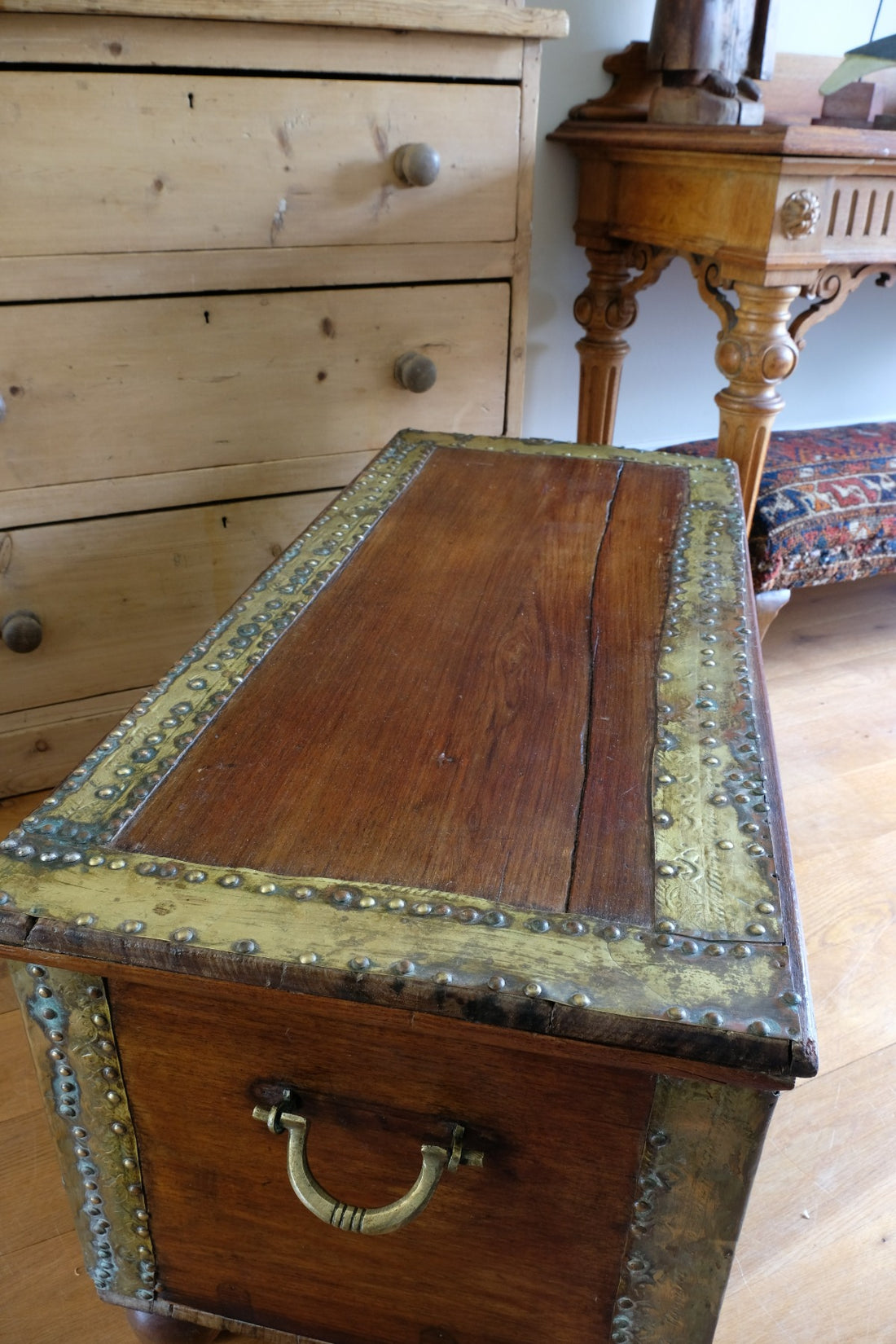 Teak Zanzibar chest decorated with brass studs raised on bun feet