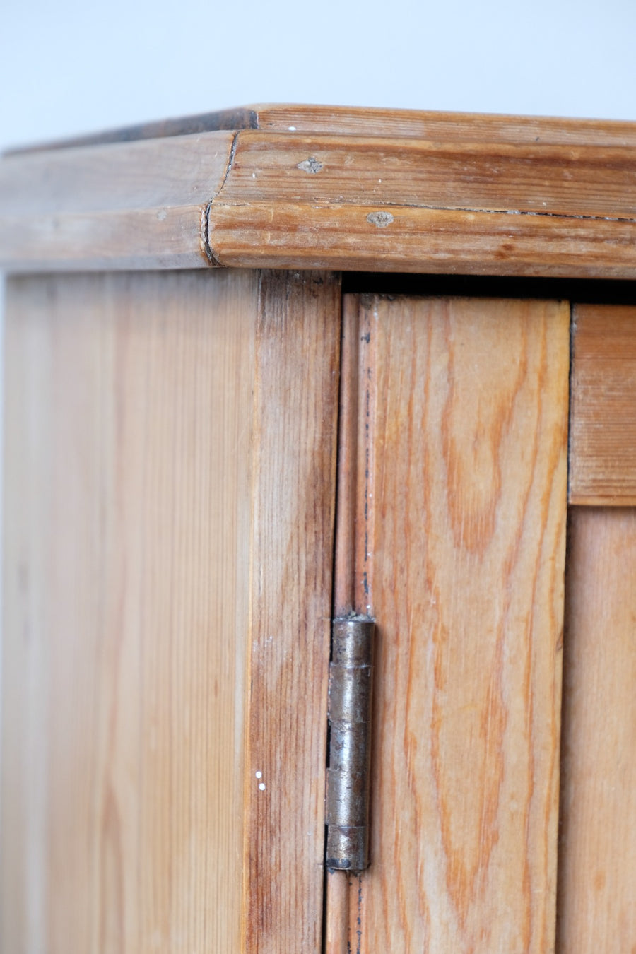 Close up brass hinge on Victorian pine cupboard

