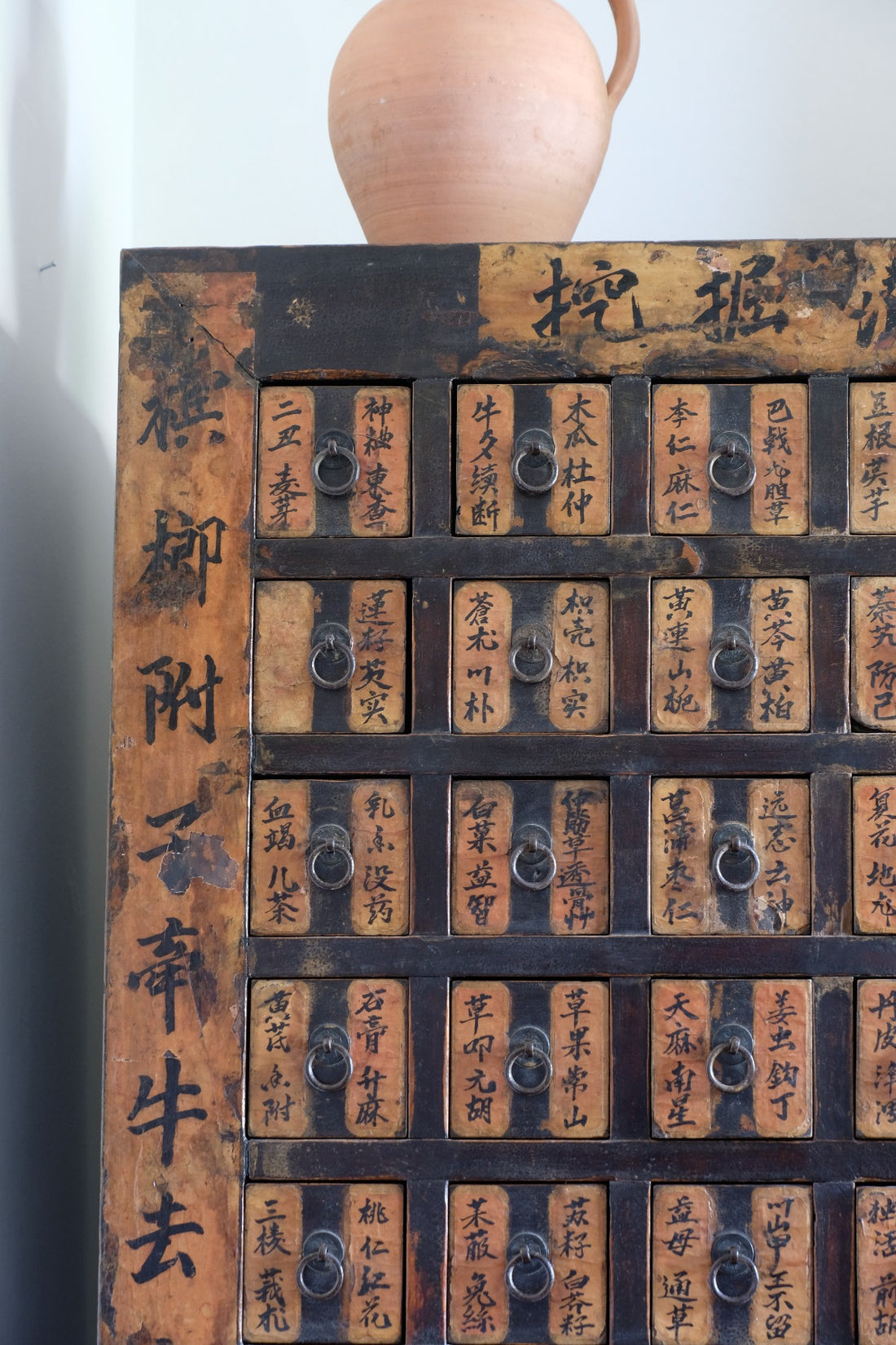 Close-up of antique Chinese storage drawers with hand-painted calligraphy
