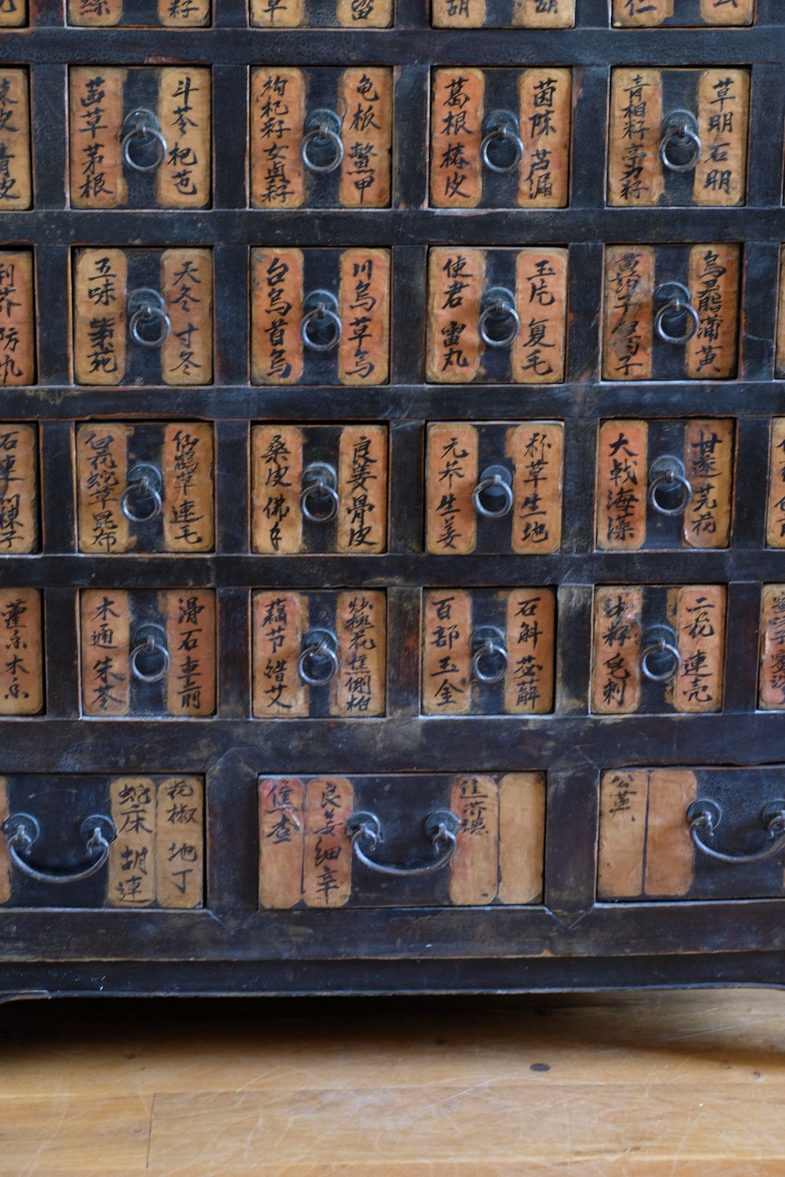 Detail of hand-painted Chinese calligraphy on antique wooden drawers