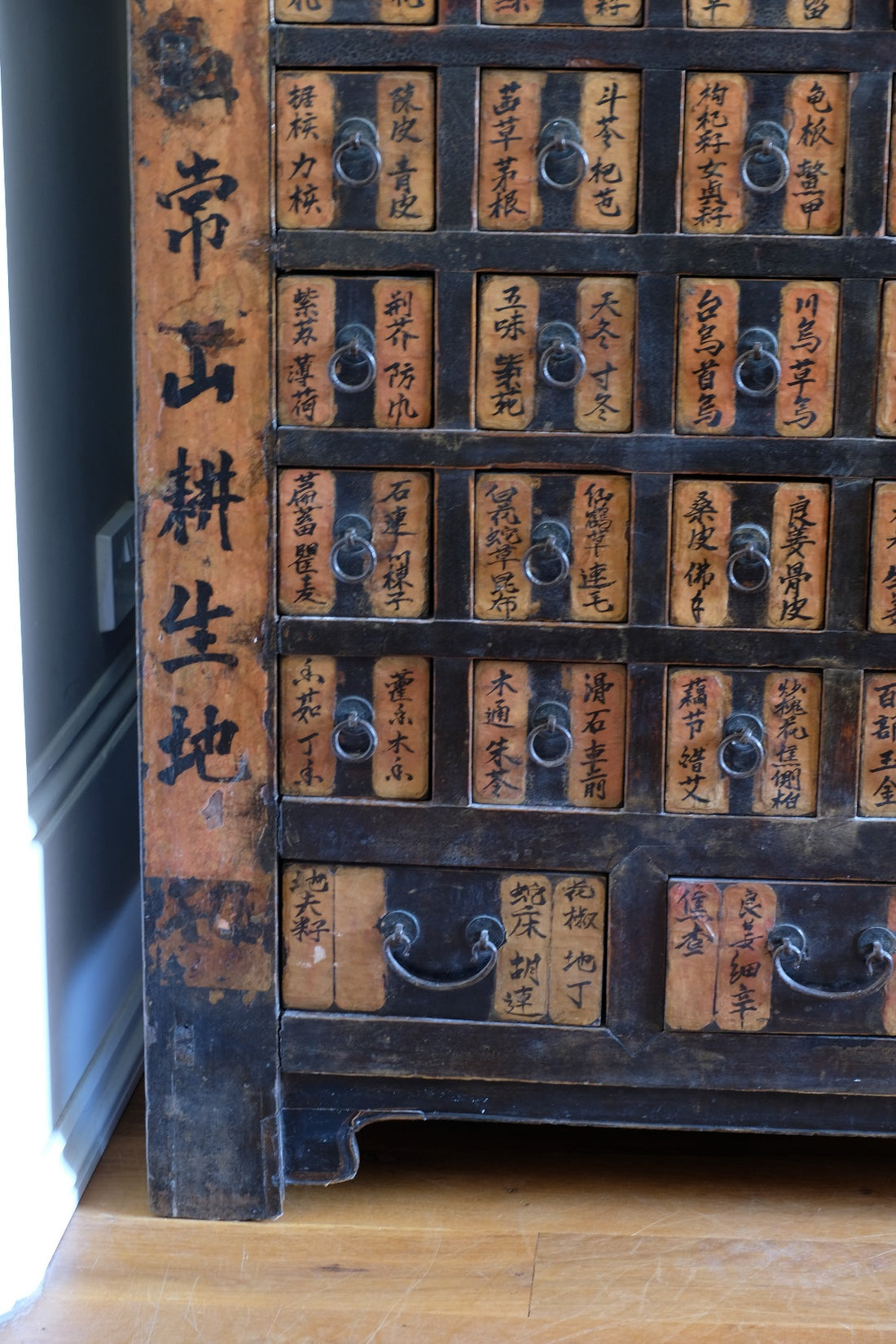 Detail of hand-painted Chinese calligraphy on antique wooden drawers