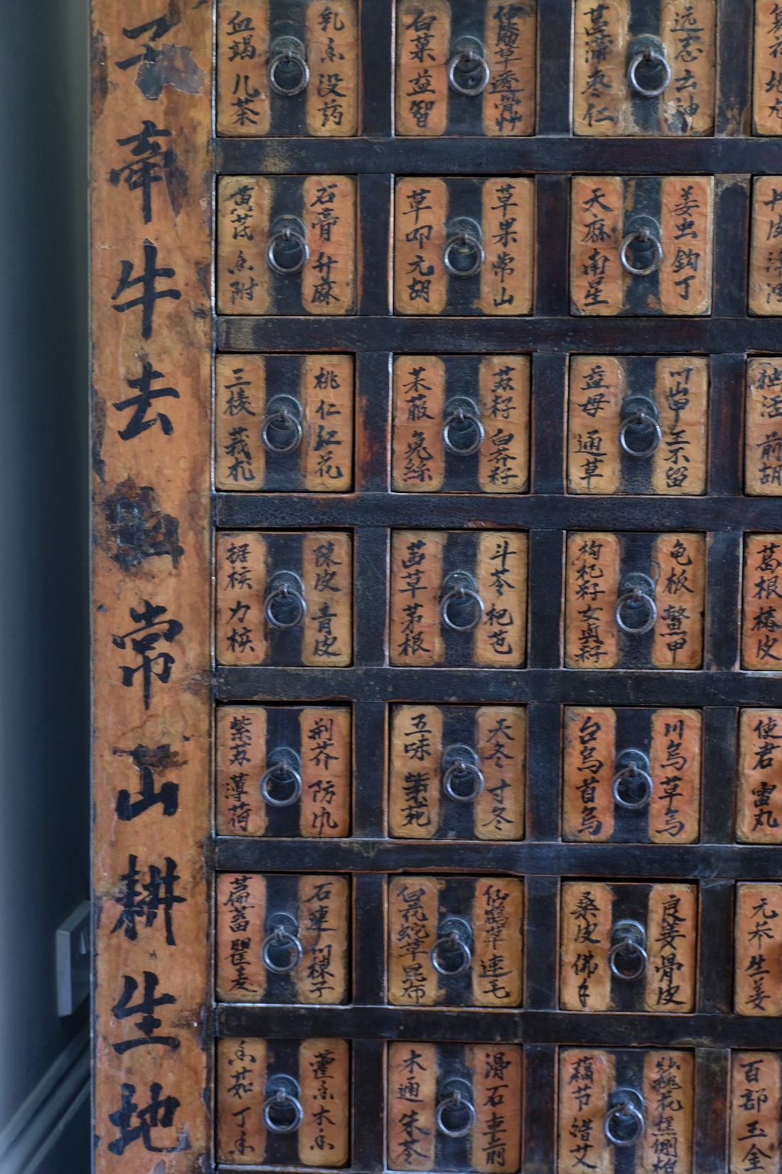 Detail of hand-painted Chinese calligraphy on antique wooden drawers