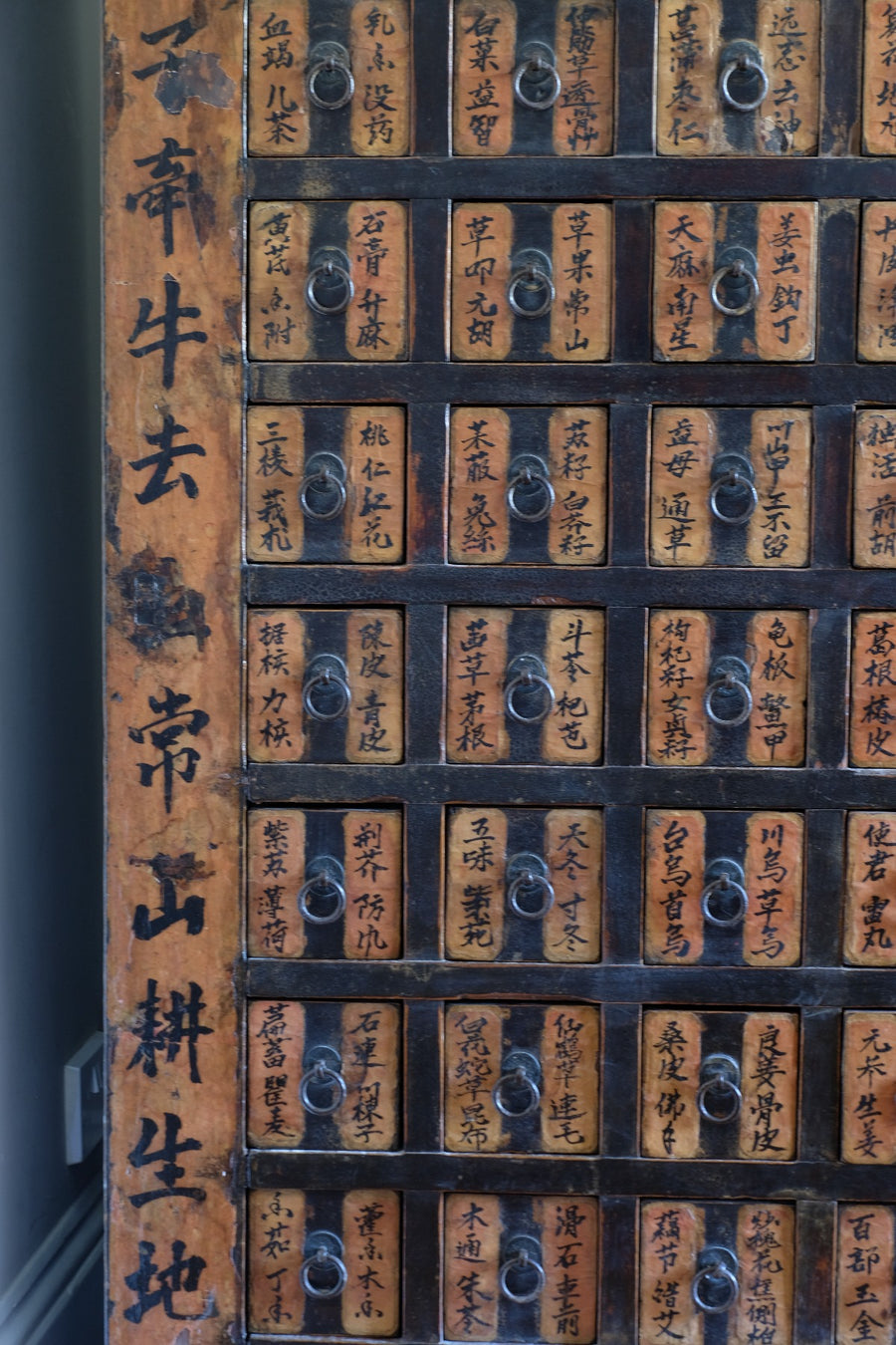 Detail of hand-painted Chinese calligraphy on antique wooden drawers