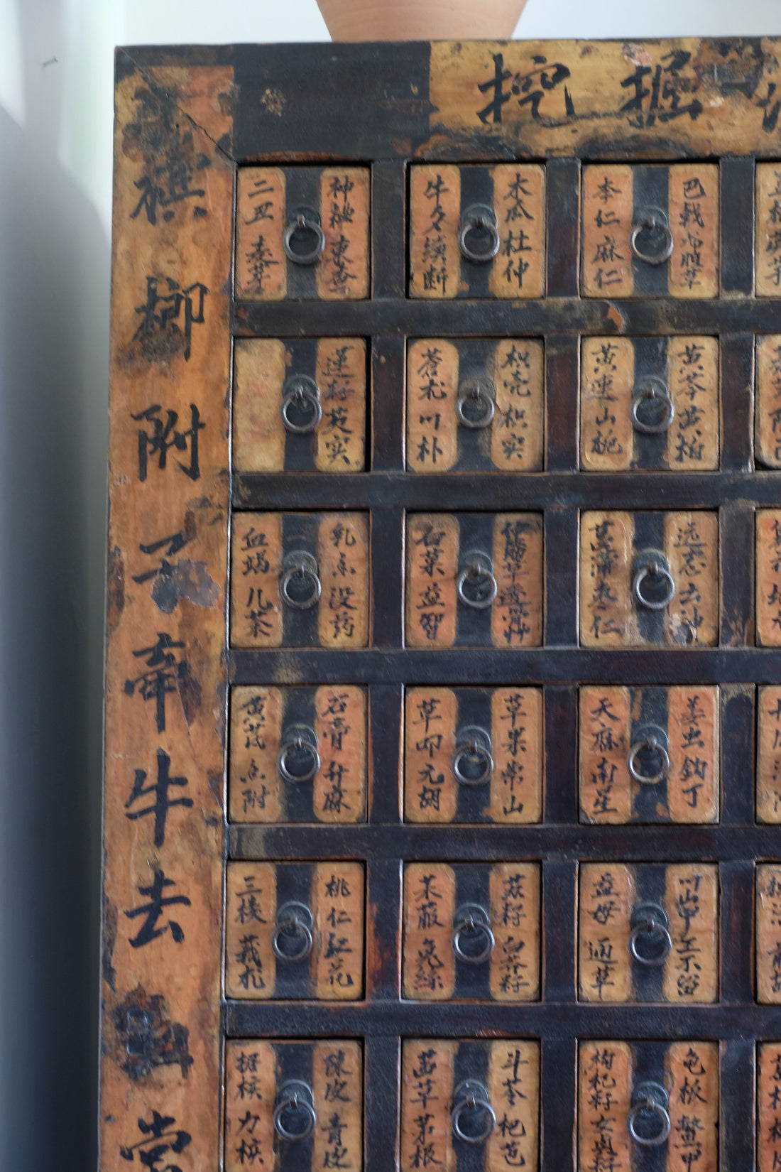 Detail of hand-painted Chinese calligraphy on antique wooden drawers