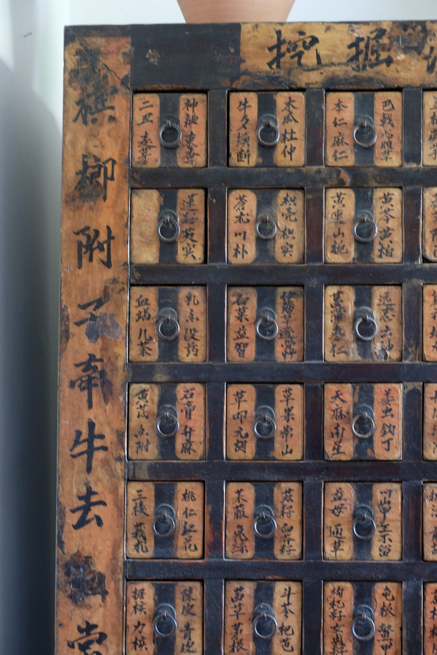 Detail of hand-painted Chinese calligraphy on antique wooden drawers