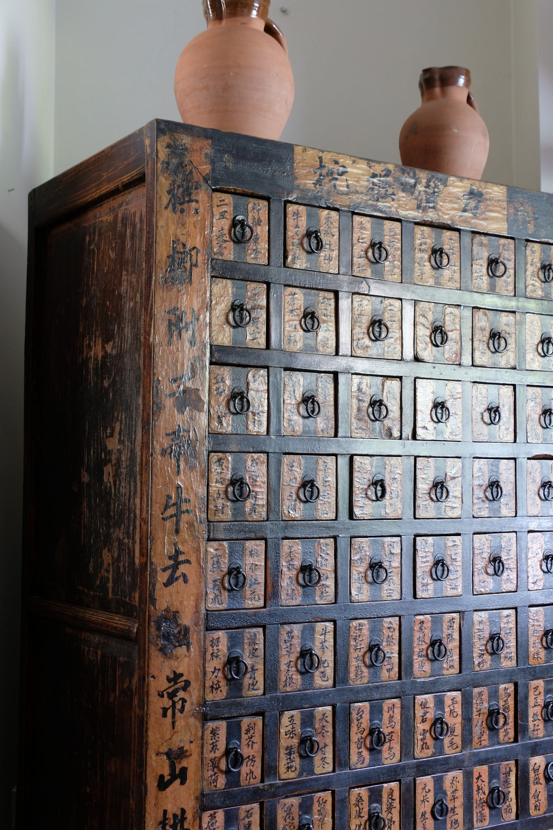 Detail of hand-painted Chinese calligraphy on antique wooden drawers