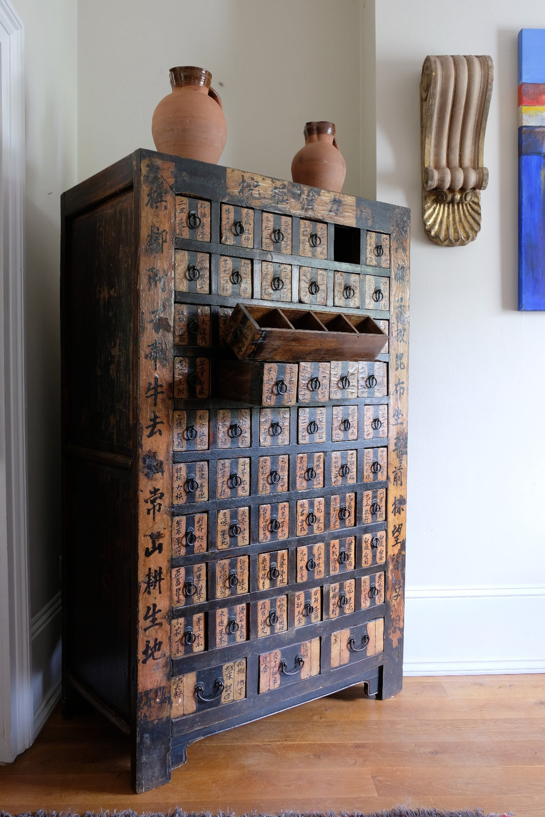 Detail of hand-painted Chinese calligraphy on antique wooden drawers