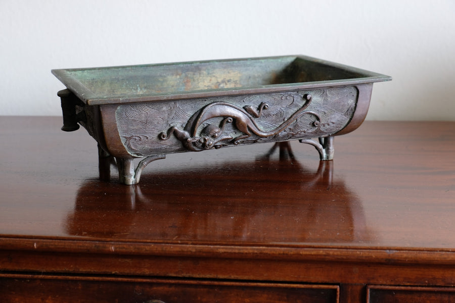 Close-up of dragon and cloud relief on Meiji Japanese bronze suiban vessel