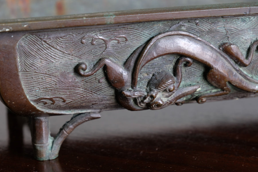 Close-up of dragon and cloud relief on Meiji Japanese bronze suiban vessel