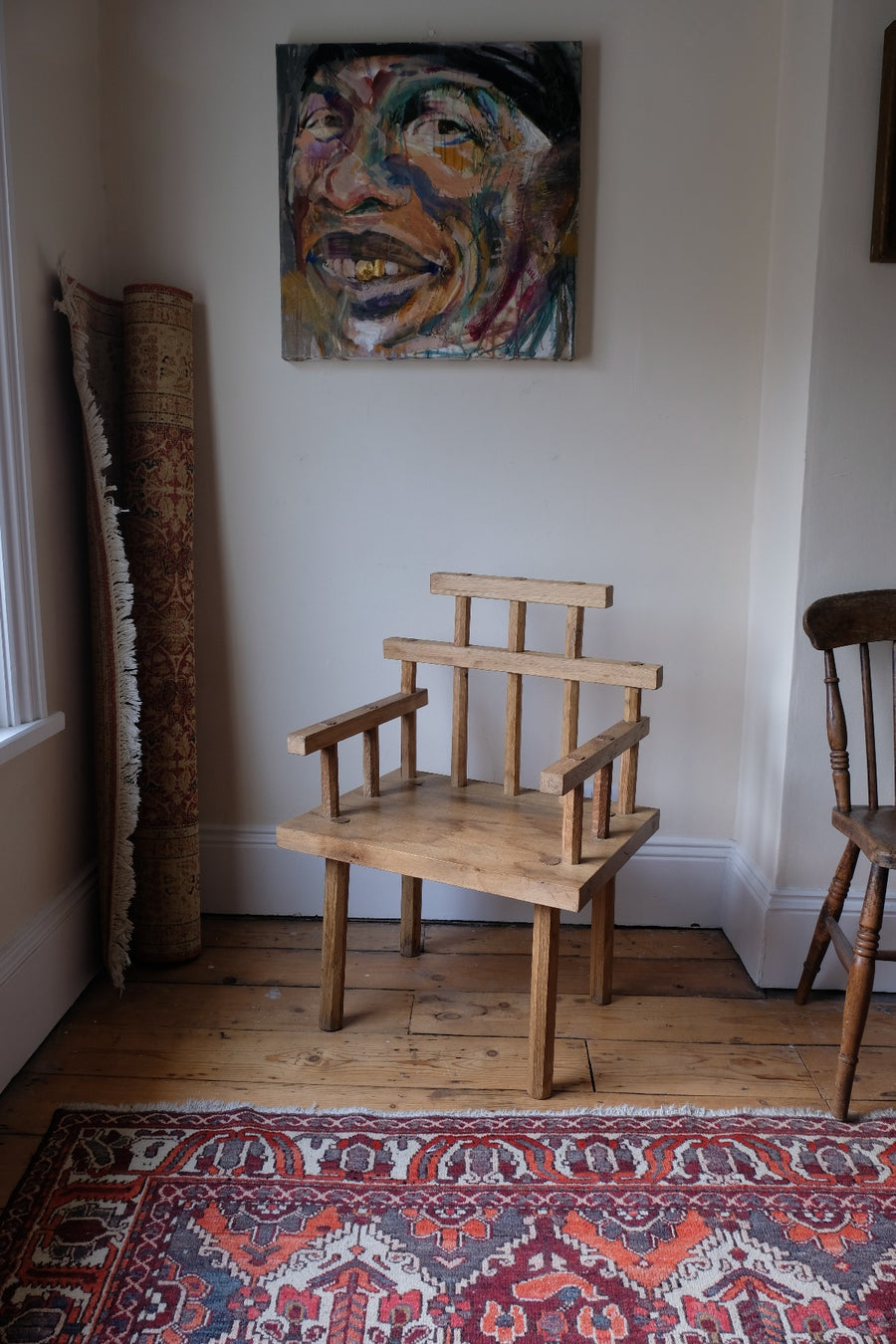 Primitive handmade wooden armchair with rustic timber finish and blocky carved design