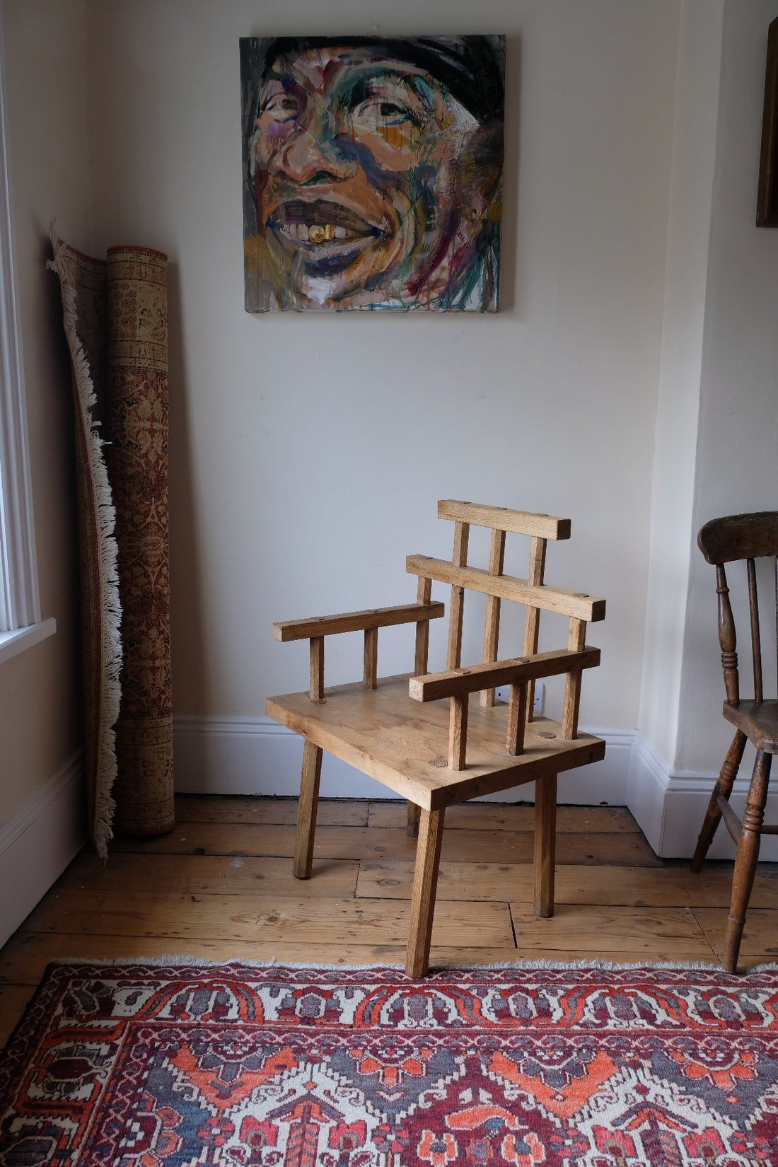 Primitive handmade wooden armchair with rustic timber finish and blocky carved design