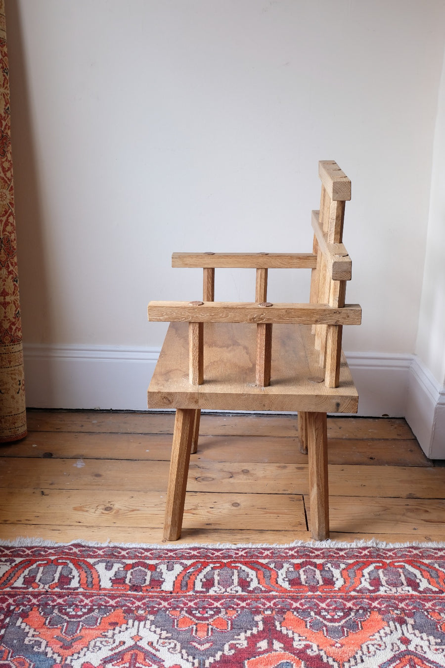 side view  - Primitive handmade wooden armchair with rustic timber finish and blocky carved design