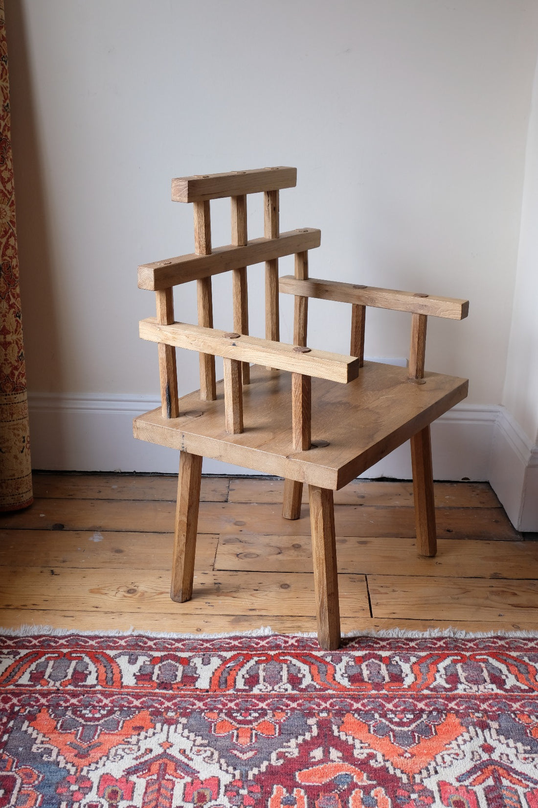 side view - Primitive handmade wooden armchair with rustic timber finish and blocky carved design
