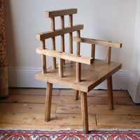 side view - Primitive handmade wooden armchair with rustic timber finish and blocky carved design