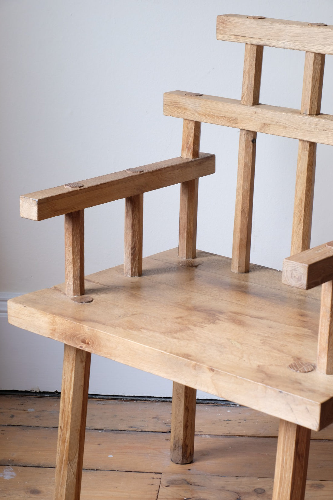 Close up - Primitive handmade wooden armchair with rustic timber finish and blocky carved design