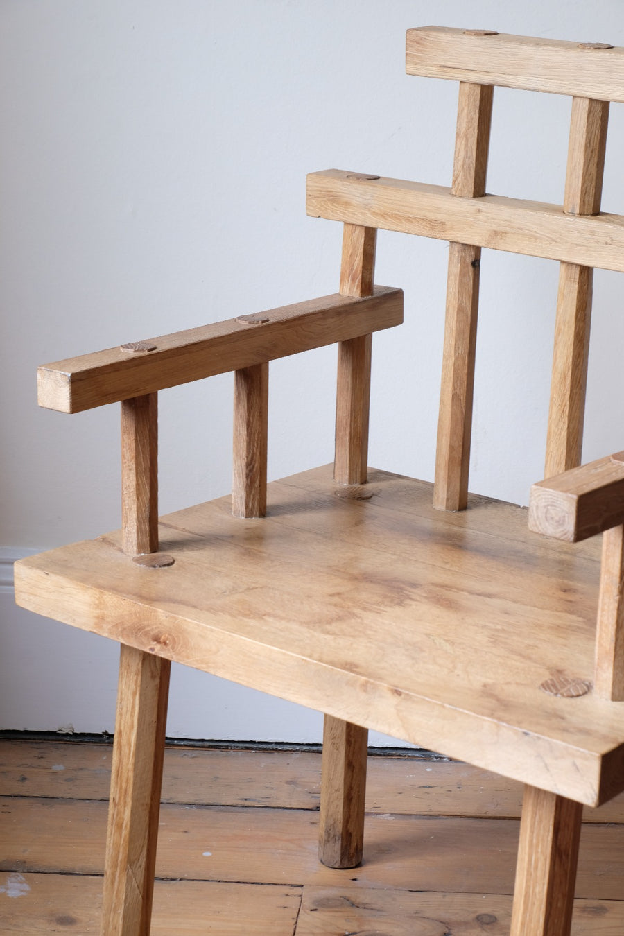 Close up - Primitive handmade wooden armchair with rustic timber finish and blocky carved design