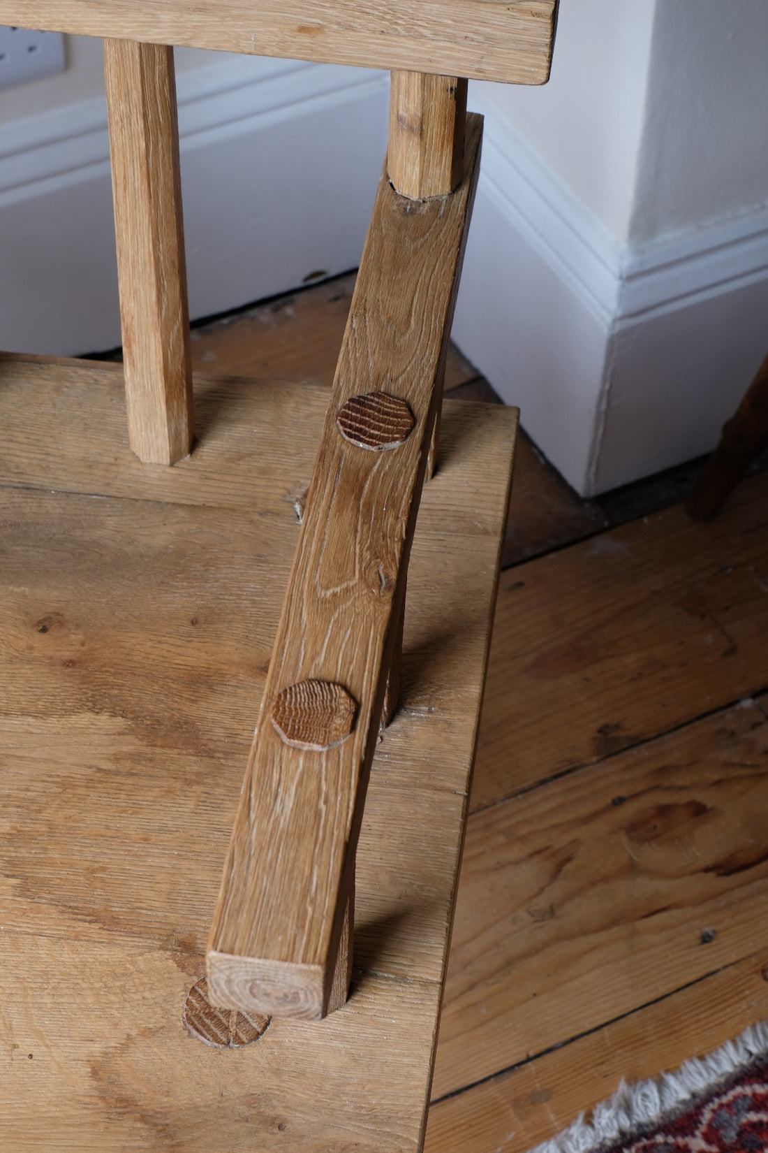 Primitive handmade wooden armchair with rustic timber finish and blocky carved design