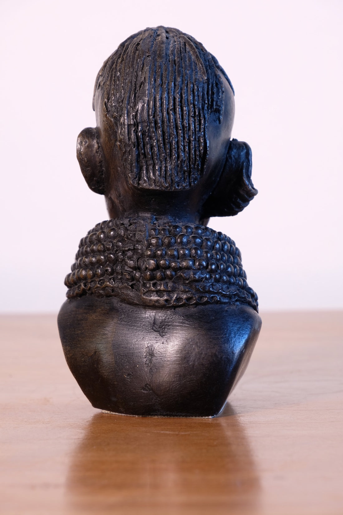 sculpture with textured beaded neck adornment