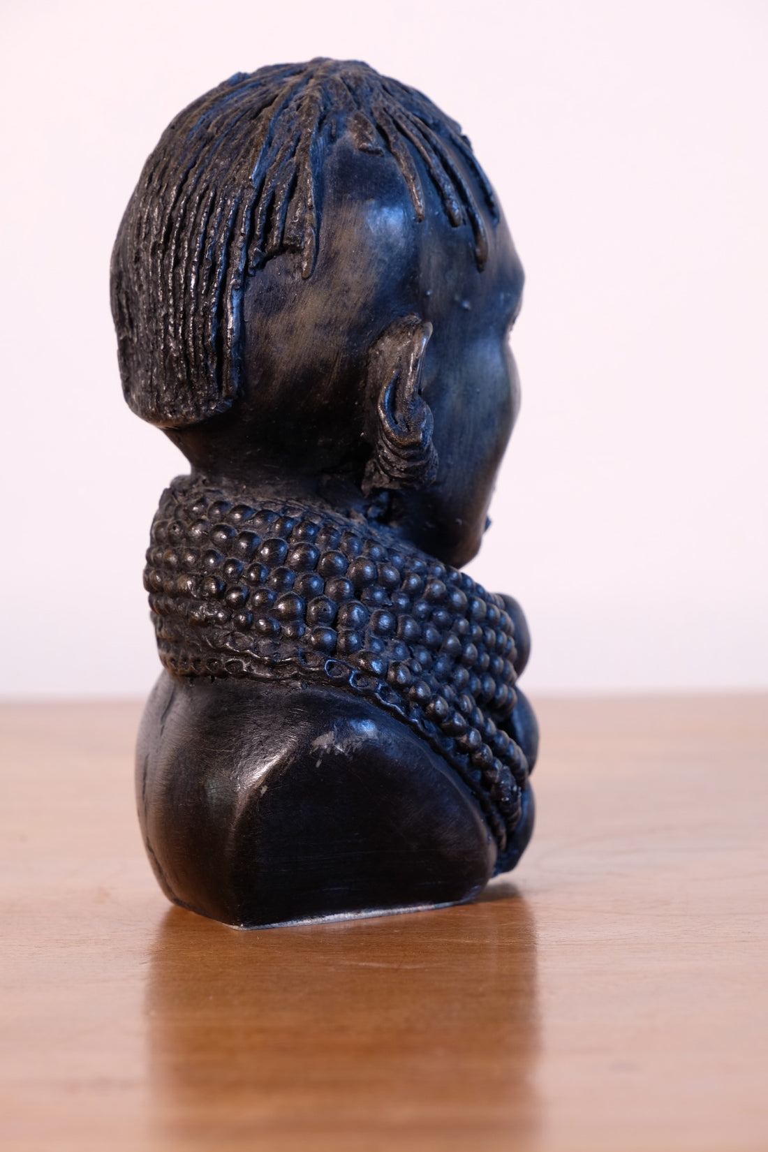 sculpture with textured beaded neck adornment