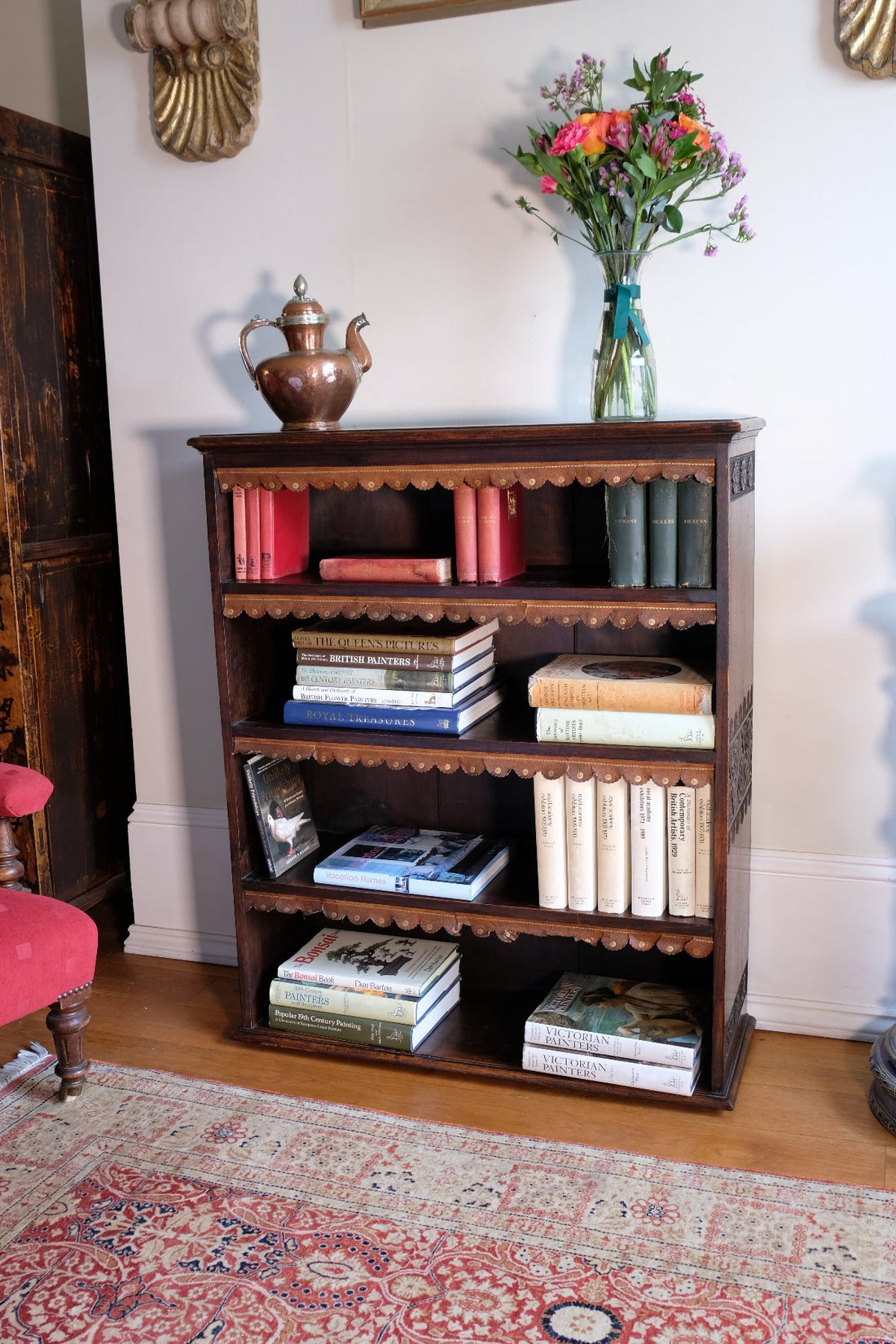 Edwardian Arts and Crafts carved oak bookcase with original tooled leather dust fringing shelves