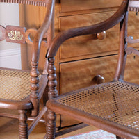curved arms a Pair of Regency mahogany armchairs with brass inlay and cane seats, circa 1810