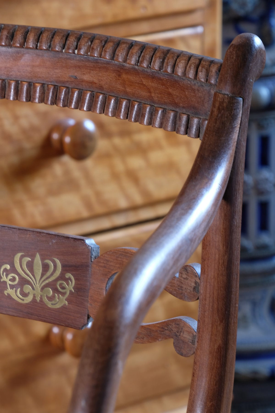 Back rail carved detail on a Pair of Regency mahogany armchairs with brass inlay and cane seats, circa 1810