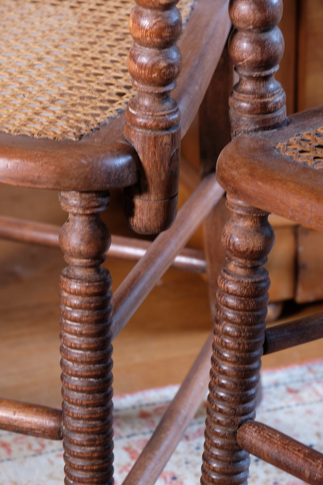 Bobbin legs on a Pair of Regency mahogany armchairs with brass inlay and cane seats, circa 1810