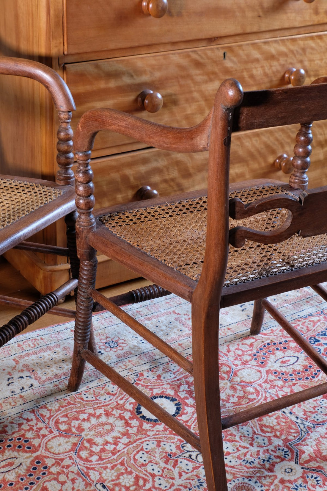 side view on a Pair of Regency mahogany armchairs with brass inlay and cane seats, circa 1810
