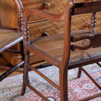 side view on a Pair of Regency mahogany armchairs with brass inlay and cane seats, circa 1810