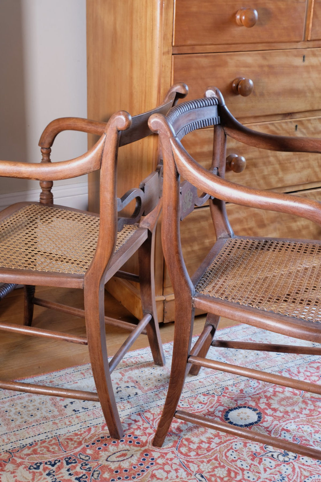 curled back support on a Pair of Regency mahogany armchairs with brass inlay and cane seats, circa 1810